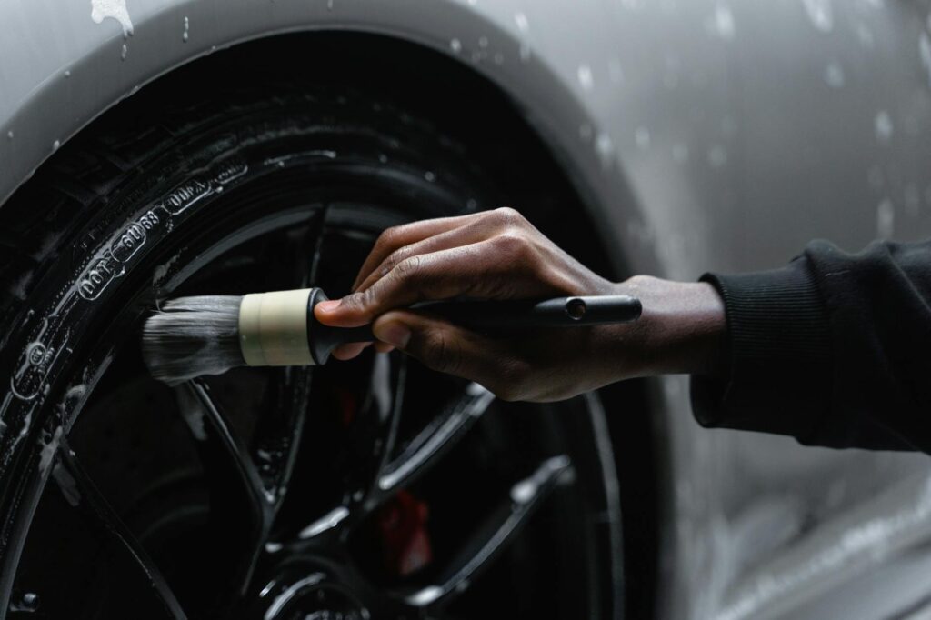 a person cleaning tire of a car